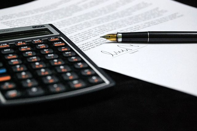 calculadora con folio y bolígrafo 